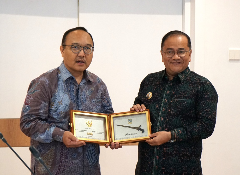 Kepala Badan Pengembangan Sumber Daya Manusia Komunikasi dan Digital (BPSDM Komdigi), Bonifasius Wahyu Pudjianto, Ph.D (kiri) menyerahkan plakat cinderamata kepada Wali Kota Jambi, Dr. dr. H. Maulana, M.K.M usai penandatanganan Nota Kesepakatan Peningkatan Kapasitas SDM Bidang Komunikasi dan Digital di Gedung Utama Kementerian Komdigi, Jakarta, Kamis (05/02/2026)