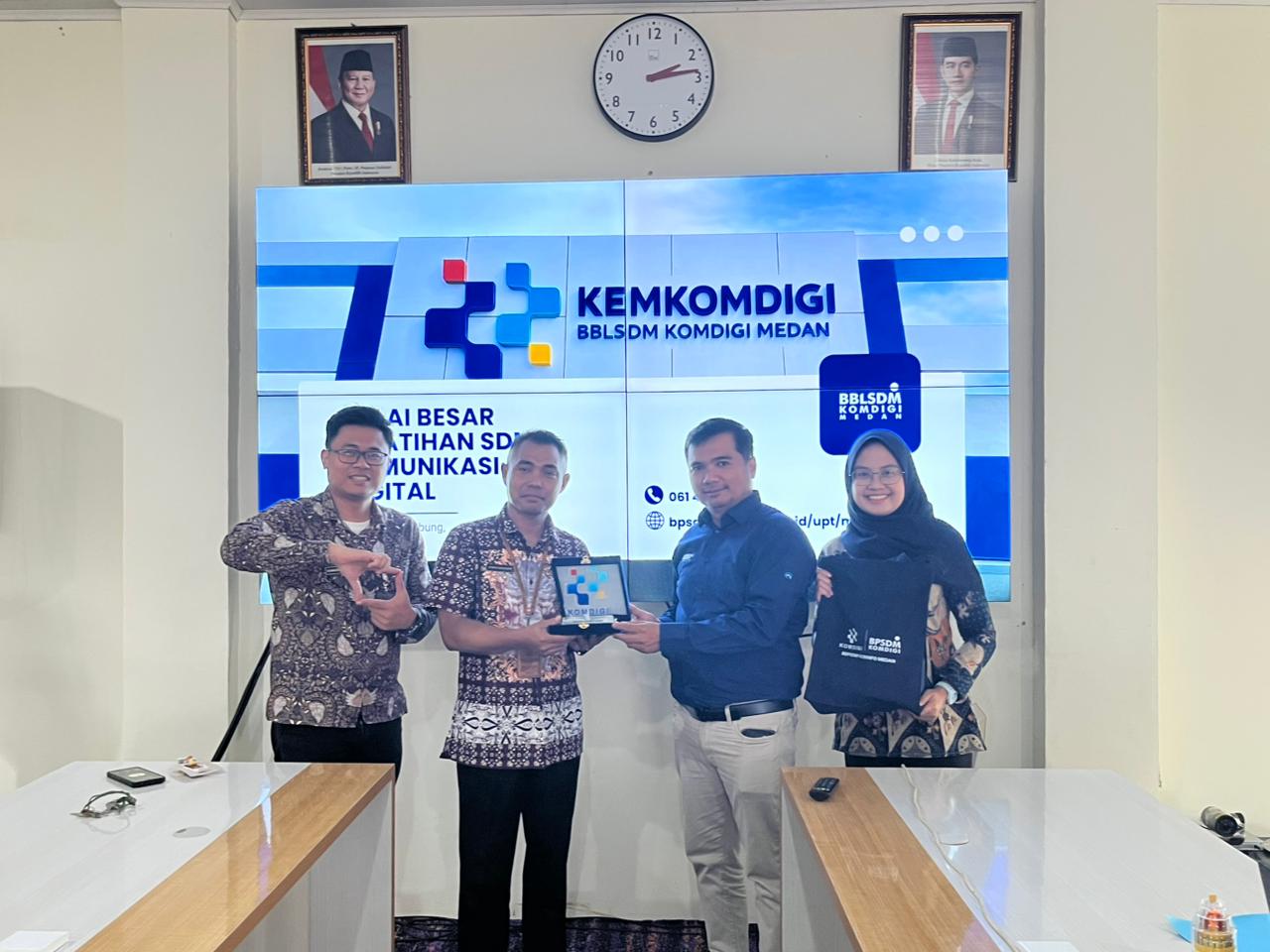 Frans H. S. Sembiring menyerahkan plakat ke Kepala Bidang Informasi dan Komunikasi Publik (IKP), Ahmad Sirajudin